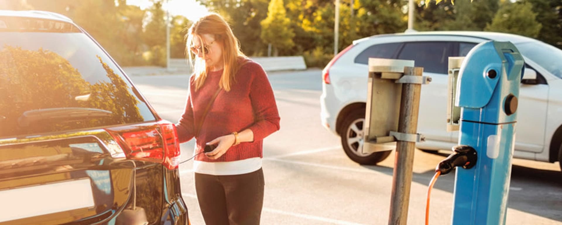 chica cargando su coche eléctrico en un punto gratuito